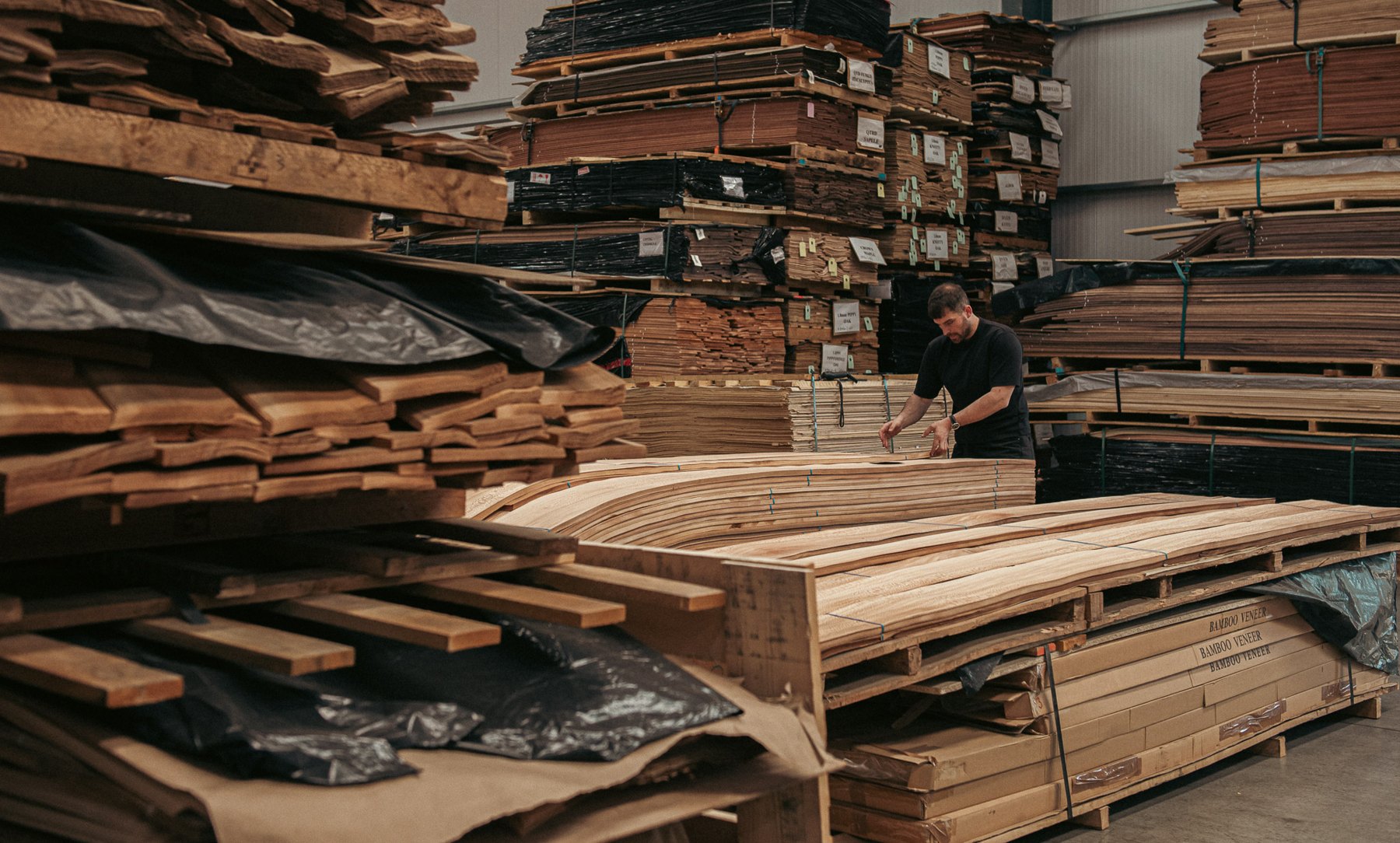 A team member handling veneer among stacks in the Capital Crispin warehouse